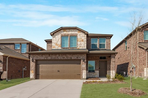 A house with a brown garage door and a brown stone wall.