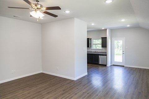 A room with a ceiling fan and wooden flooring.
