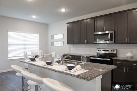 A kitchen with a counter and stools.