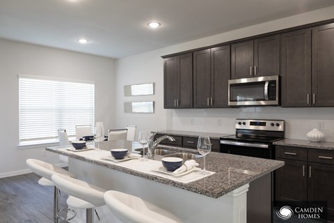 A kitchen with a counter and stools.