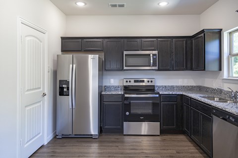 A kitchen with black cabinets and stainless steel appliances.