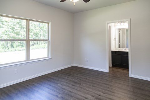 A room with a ceiling fan and a large window.