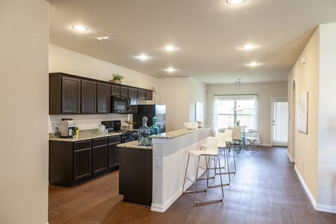 A kitchen with dark brown cabinets and a white island.