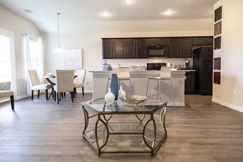 A modern kitchen with dark wood cabinets and a glass table.