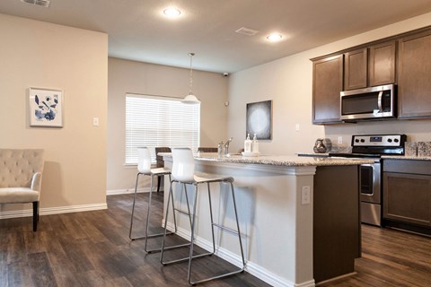 A kitchen with a white counter and brown cabinets.