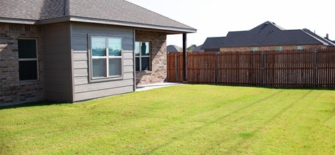 A house with a grey exterior and a brown fence.