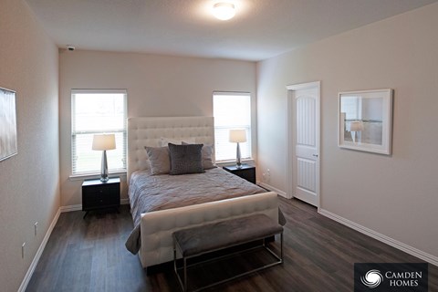 A bedroom with a large bed and a bench in front of it.