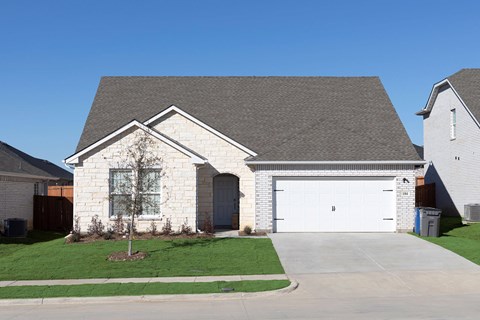 A house with a grey roof and a white garage door.