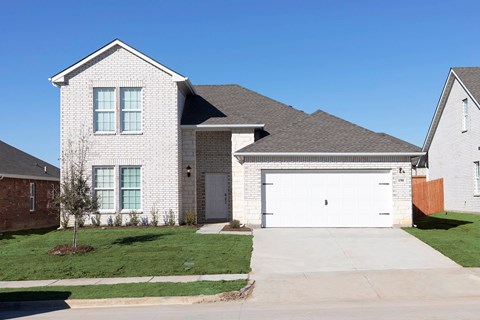 A white house with a grey roof and a garage door.