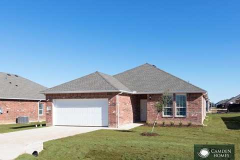 A brick house with a Camden Homes sign in the front yard.