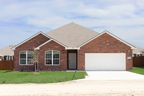A house with a brown brick exterior and a white garage door.