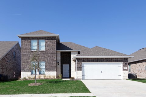 A house with a grey roof and a white garage door.