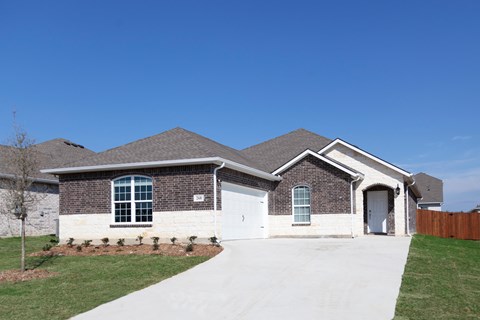 A house with a white garage door and a brown roof.
