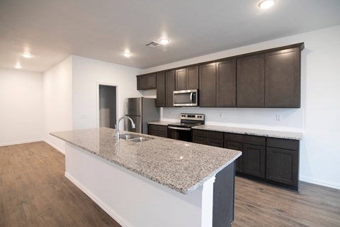 A kitchen with brown cabinets and a granite countertop.