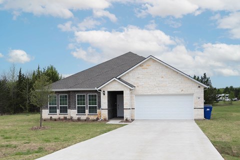 A house with a grey roof and a white garage door.