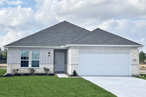 A house with a grey roof and a white garage door.