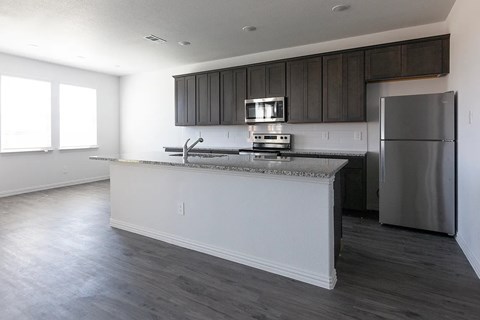 A kitchen with a stainless steel refrigerator and a white countertop.