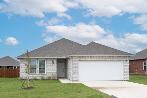 A house with a grey roof and a white garage door.