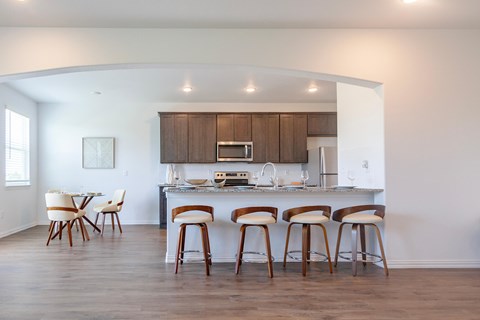 A kitchen with a bar stool and a table.