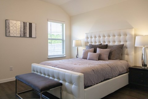 A bedroom with a large bed and a window.
