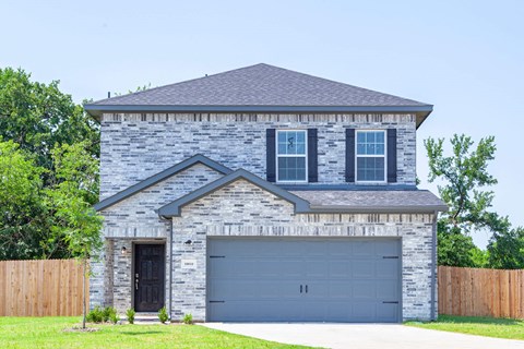 A house with a grey garage door and a black door.