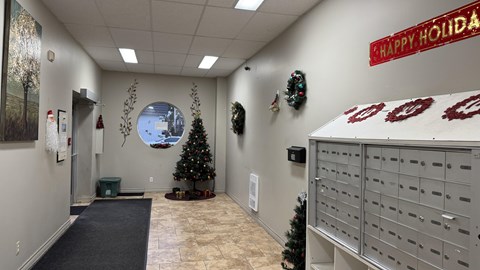 A room with a Christmas tree and a sign that says "Happy Holidays".