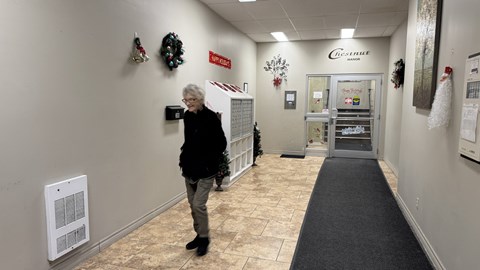 A woman is standing in a hallway with a sign that says "EXIT".