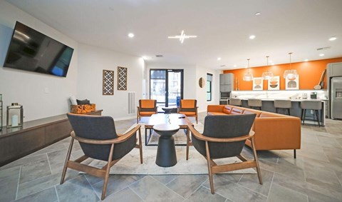 A modern living room with a grey sofa and wooden chairs.