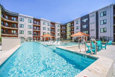 A swimming pool in front of apartment buildings.