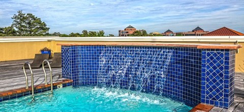 A blue tiled pool with a waterfall feature.