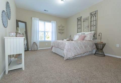 A bedroom with a large bed and a dresser.