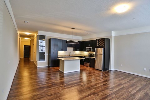 A spacious kitchen with dark wood cabinets and a white island.