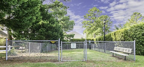 A park with a fence and bench.