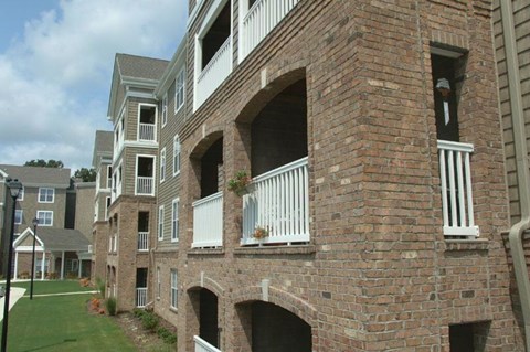 A brick building with a balcony and a window.