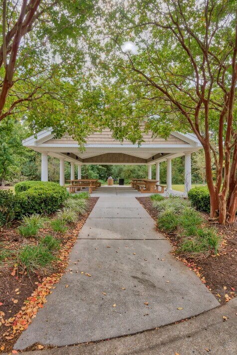 A gazebo is surrounded by trees and shrubs.