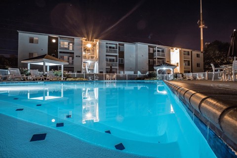 A swimming pool at night with lights reflecting on the water.