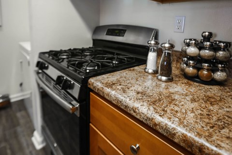 A kitchen counter with a variety of spices on it.