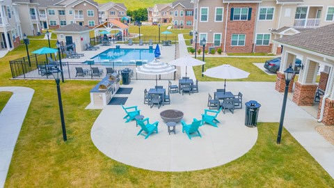 An aerial view of a pool surrounded by chairs and umbrellas.