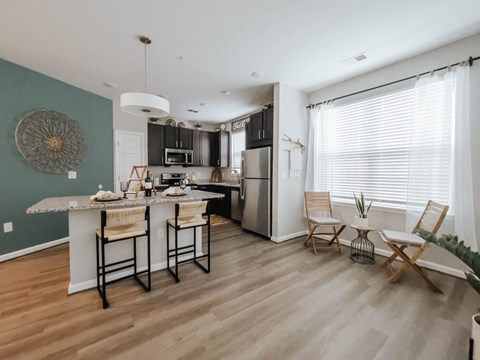 A kitchen with a table and chairs by the window.