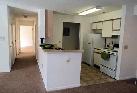 A kitchen with white appliances and a white island.