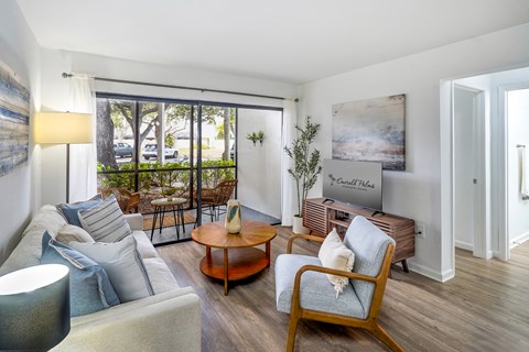 A living room with a sofa, a chair, a coffee table, and a painting on the wall.