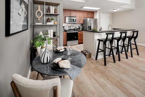 A modern kitchen with a dining table set for two.
