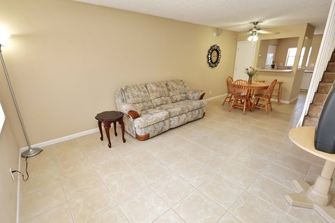 A living room with a couch, chair, and television.