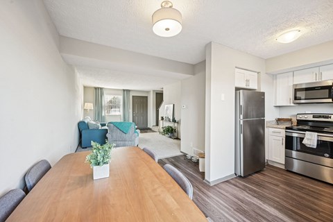 A kitchen with a refrigerator, oven, and microwave.