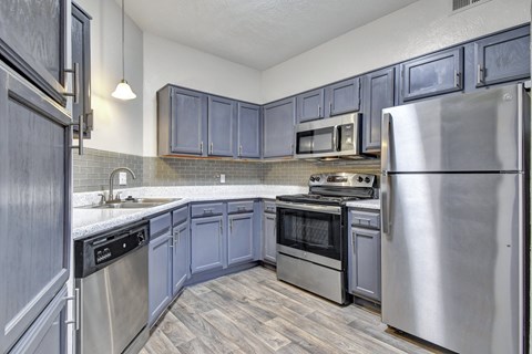 A kitchen with a stainless steel refrigerator and oven.