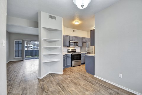 A kitchen with a white counter and a white fridge.