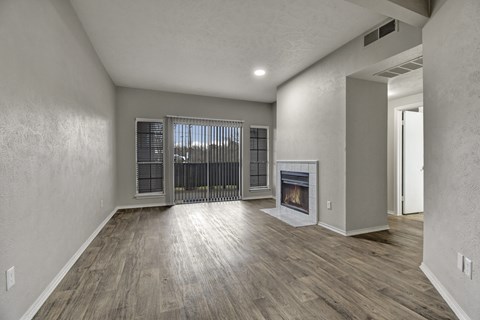 A spacious living room with a fireplace and sliding glass doors.