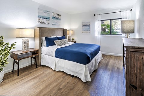 A bedroom with a large bed and a wooden table.