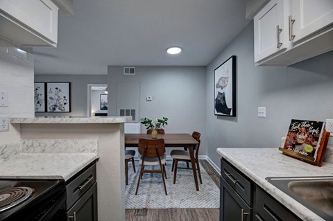 A kitchen with a table and chairs in the middle.