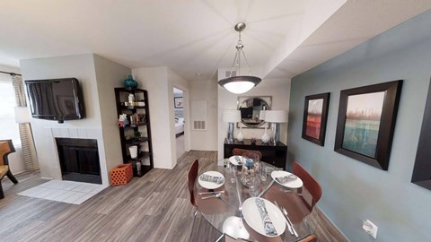 A dining room with a wooden table set for six.